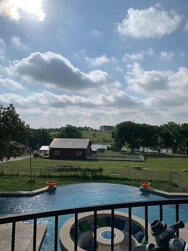 swimming pool from deck with barn in distance