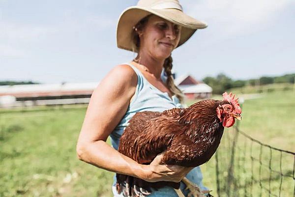  woman holding red chicken