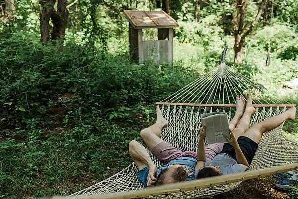 two people lying in hammock reading a book