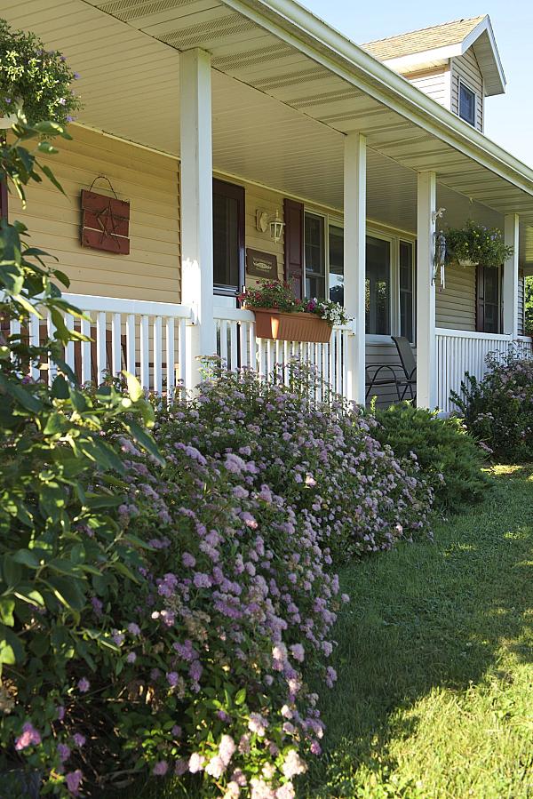 Front porch on the farm house with gardens along the front at Valley Springs Farm B&B 