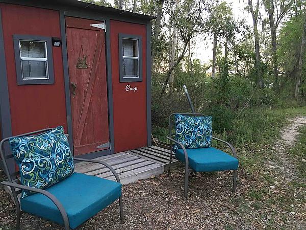 outside of red cabin with two blue chairs