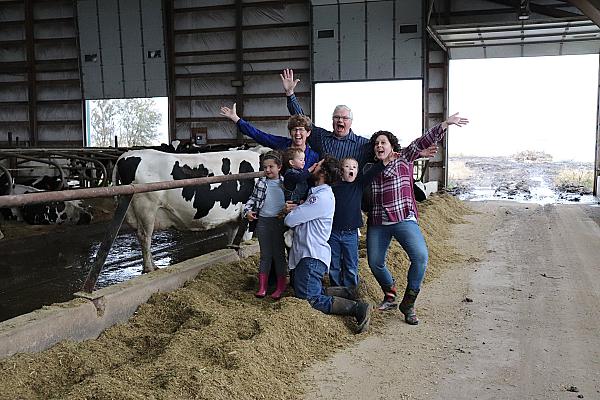 Family posing for picture in the dairy barn