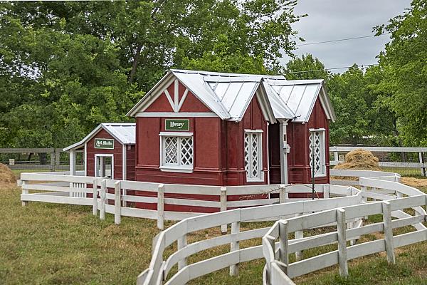 red house with white roof and fencing