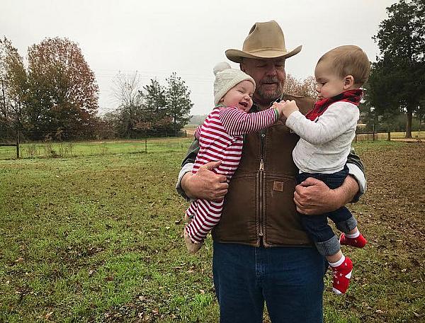 Farmer with children at White Oak Pastures, Bluffton, Georgia