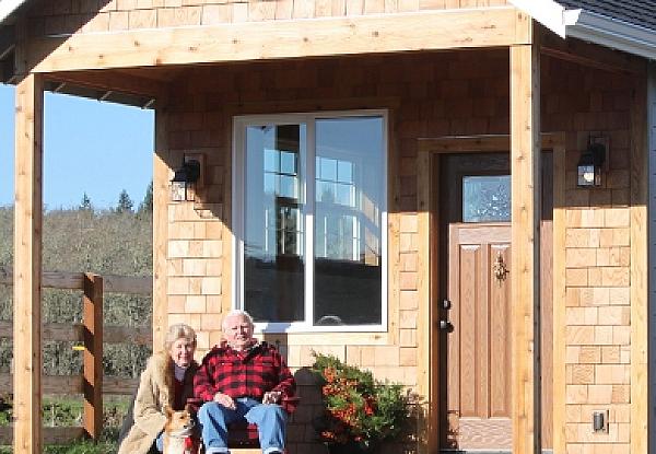 two people sitting on bench on a cabin porch