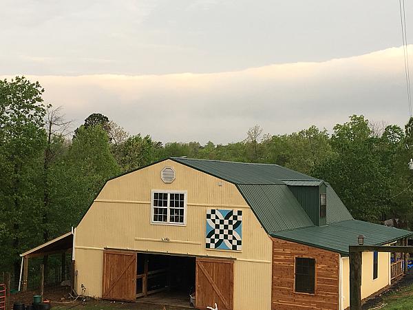 yellow barn with painted barn quilt on exterior