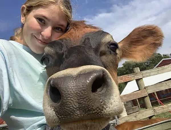 a girl posing with a cow