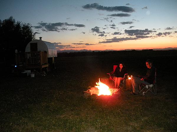 a couple sitting at a campfire