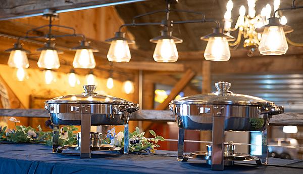 Rustic and Elegant Buffet Setting with Hanging Edison Lights and Stainless Chafing Pans