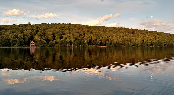 Scenic view of a lake with hills and trees in the background