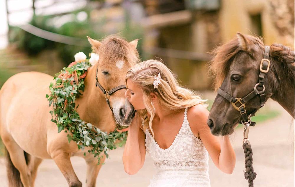 Woman in a wedding dress with two horses