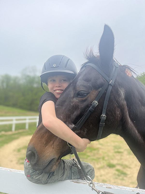 child hugging horse head