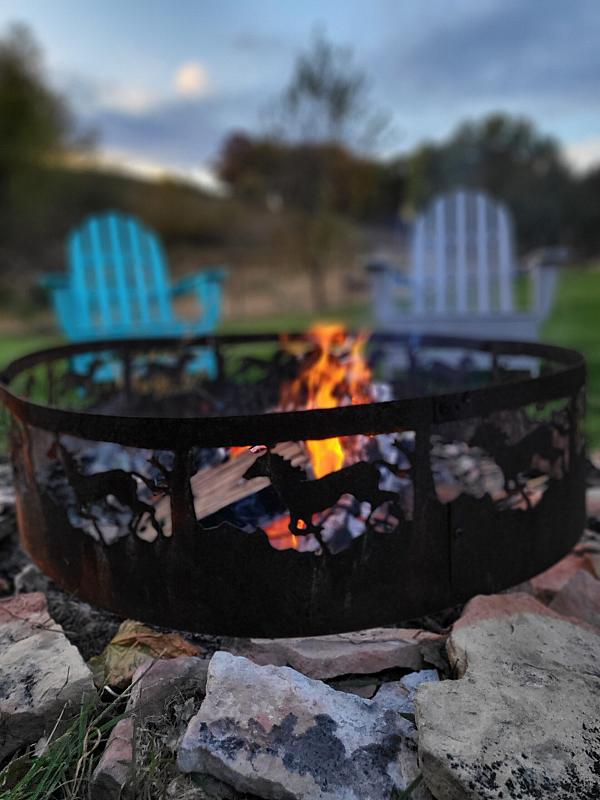 fire pit with two blue chairs