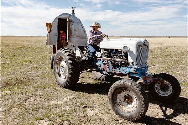 farmer on tractor pulling a shepherds wagon