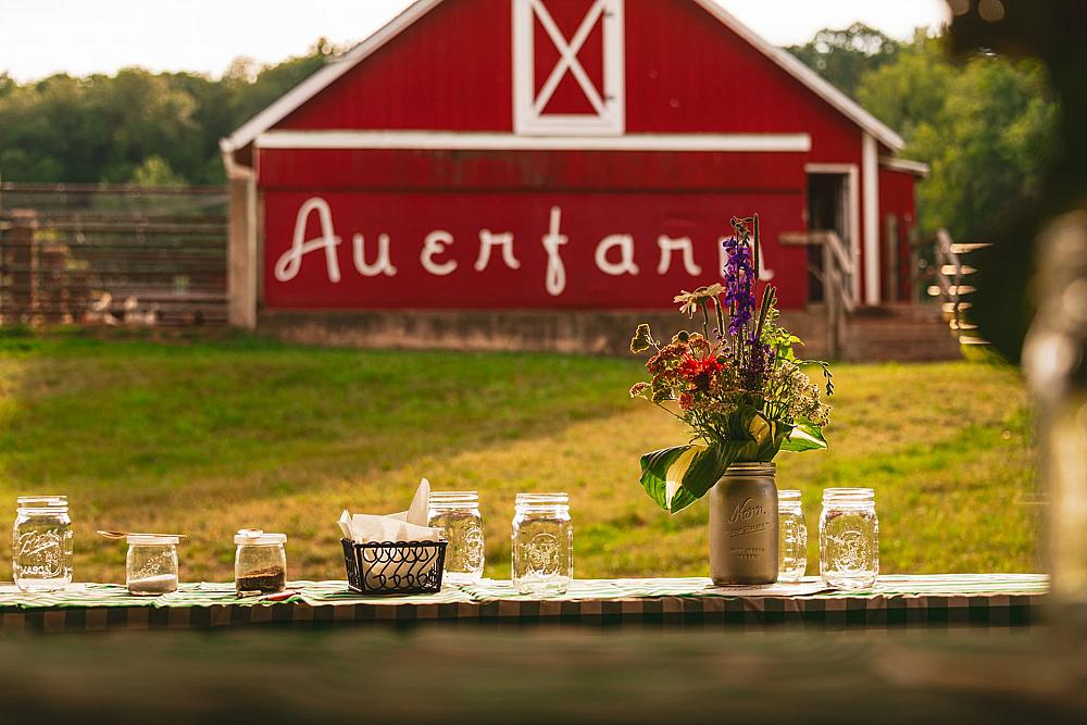 Featured Image - view out window of red barn with name of farm on it