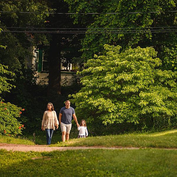man, woman, and child walking on a trail