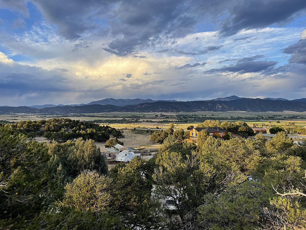 Featured Image- drone picture of the lodge and land with green trees and mountains in the distance
