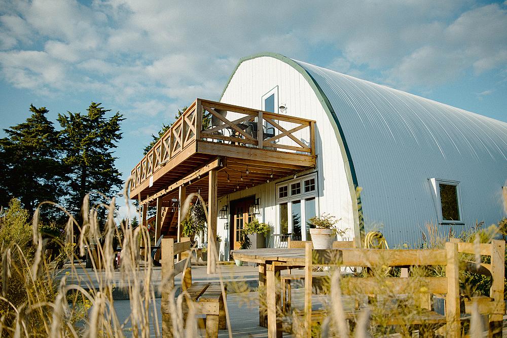 Featured Image - white domed barn with deck on second level
