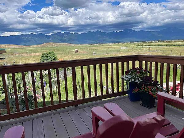 Featured Image - deck view of mountains in the distance with two red chairs