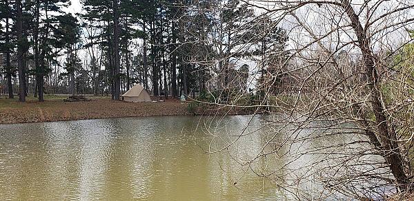 tent in the woods on the bank of a river