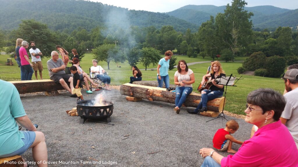 people sitting around a campfire enjoying music