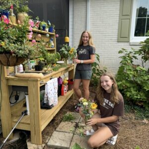 two girls with flowers making arrangements