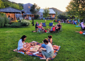 people sitting on blankets on a farm eating pizza