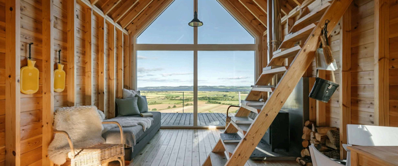 looking through a brightly lit cabin in the Highlands of Scotland out the window to the Guardswell Farm