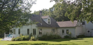 a white houe with trees surrounding it