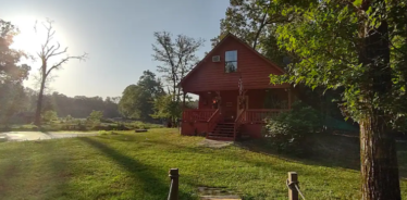 a farmhouse with the sun in the background