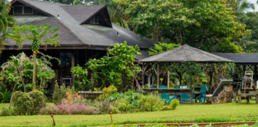 a house in hawaii with gardens in front of it