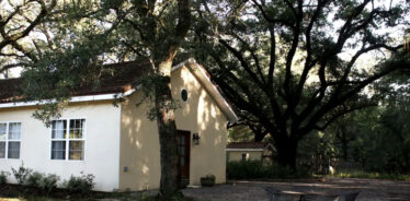a white house shaded under trees