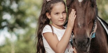 girl petting a horse