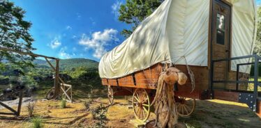 a covered wagon with mountains in the background