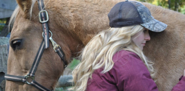 woman hugging a palomino horse