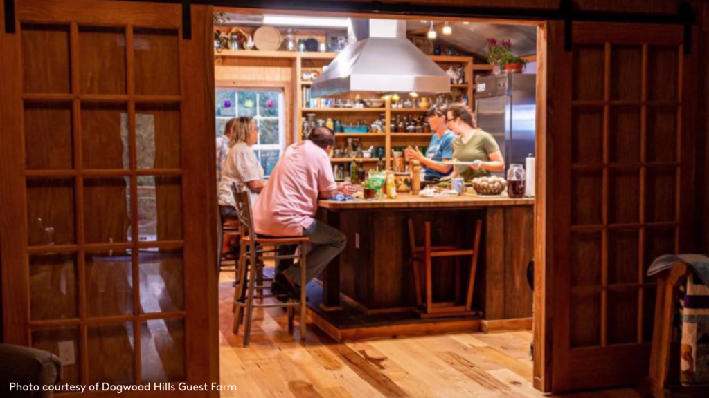 A view into the kitchen at Dogwood Hills Farm where hosts are chatting with guests and cooking with them